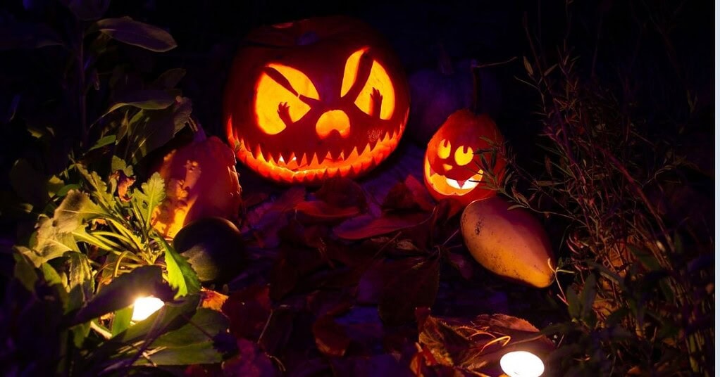 Glowing jack-o&rsquo;-lanterns in a tropical garden at night, setting a spooky Halloween mood in Bali.